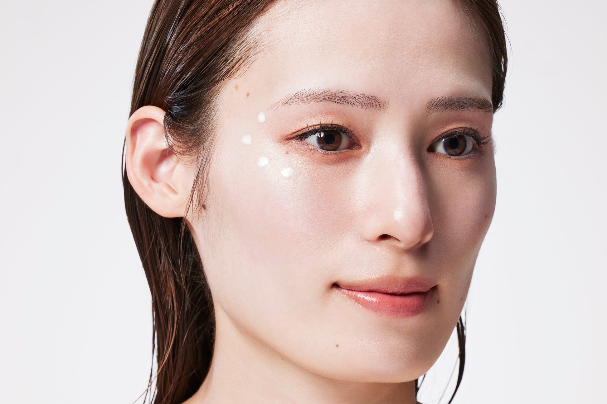 美容液リキッドハイライト、リキッドハイライト、ハイライト、モデルがテクスチャーを頬にのせる